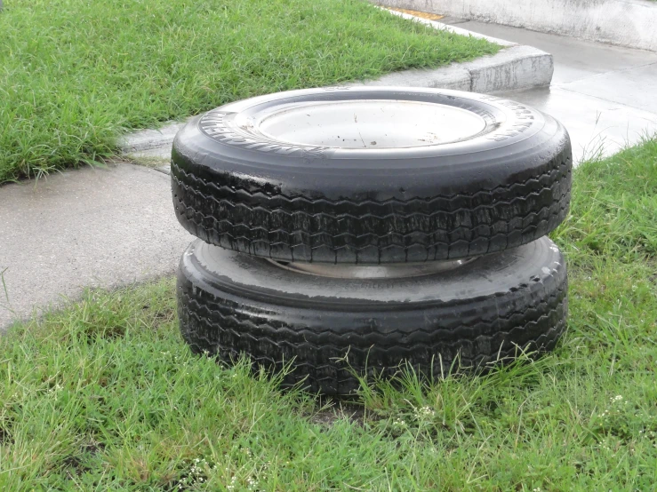 tires on the grass next to the road in a city