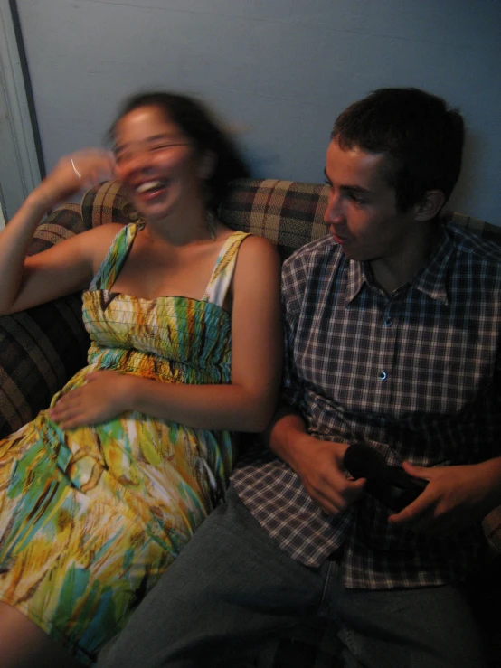 a woman sitting on a couch next to a man