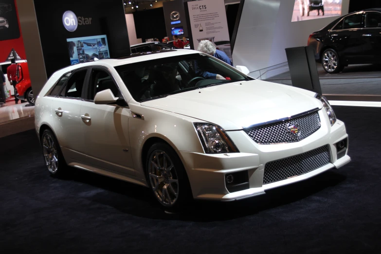 an all white cadillac on display at a car show