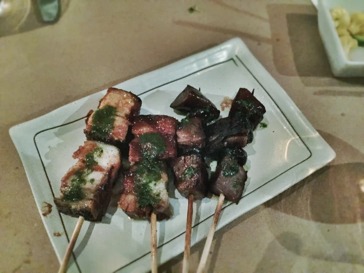 small skewered beefs covered in green sauce