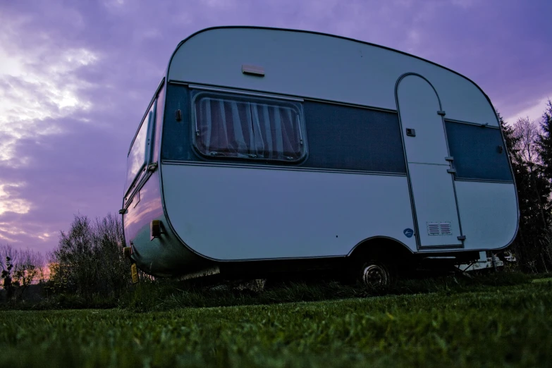 the back end of a parked camper on grass