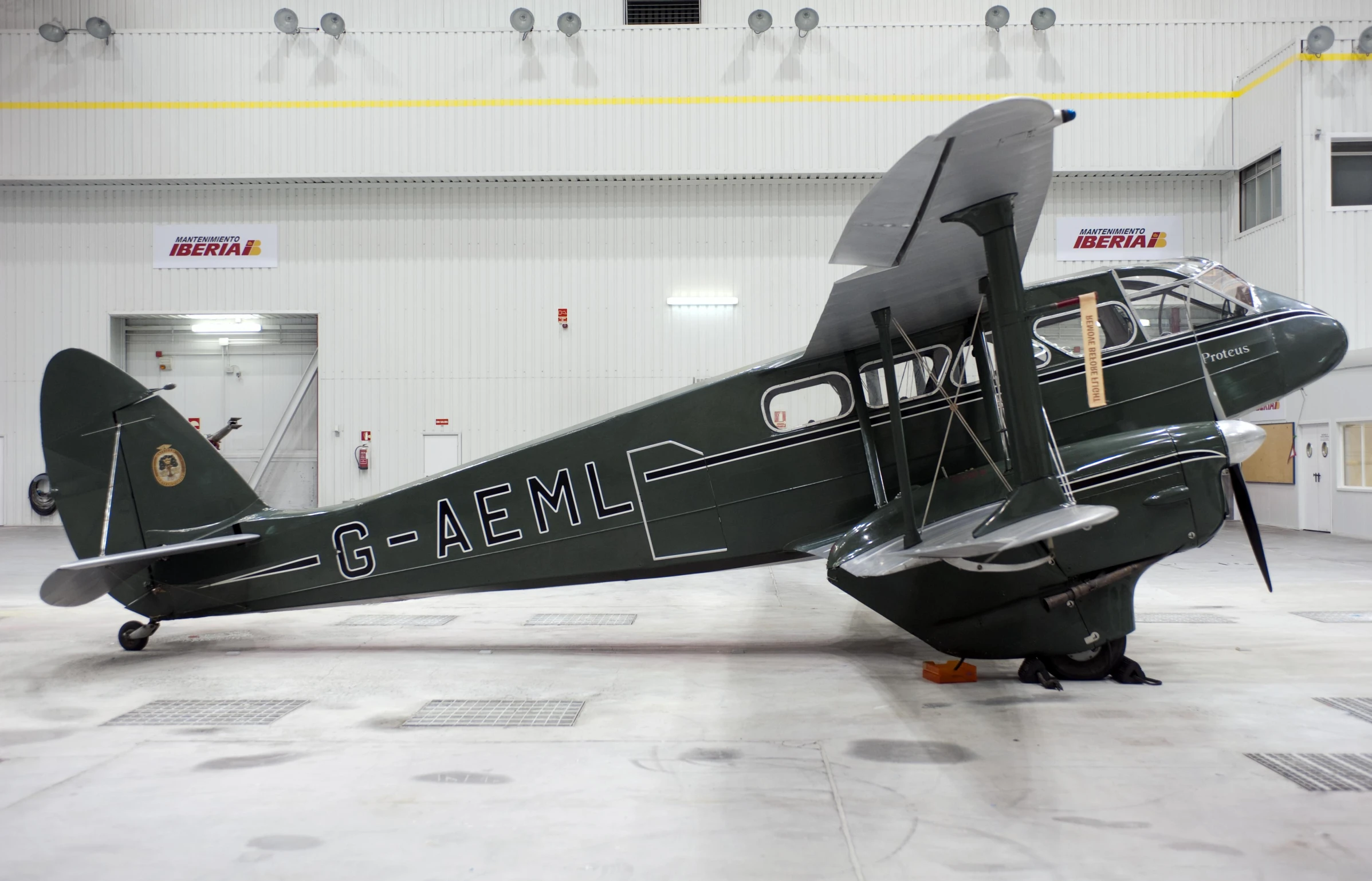 a propeller plane is displayed in a hanger