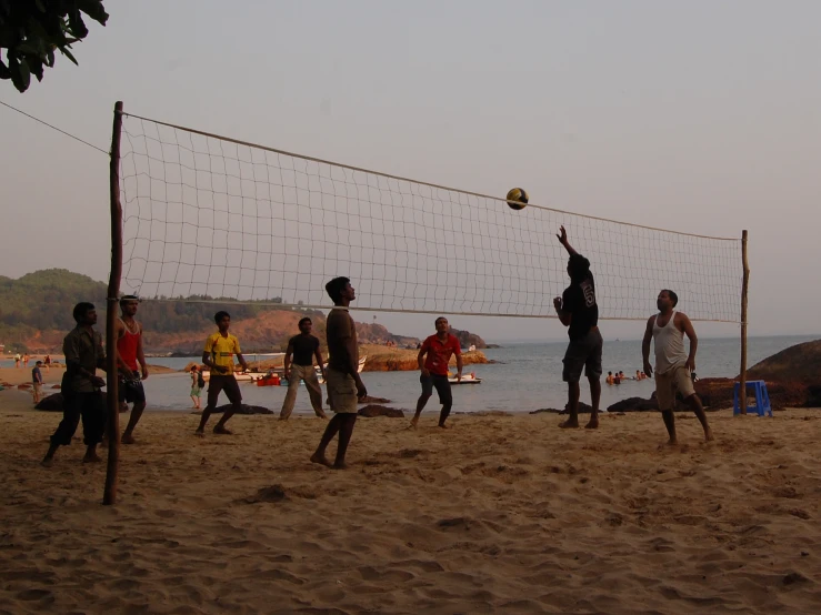 group of people on the beach playing volleyball