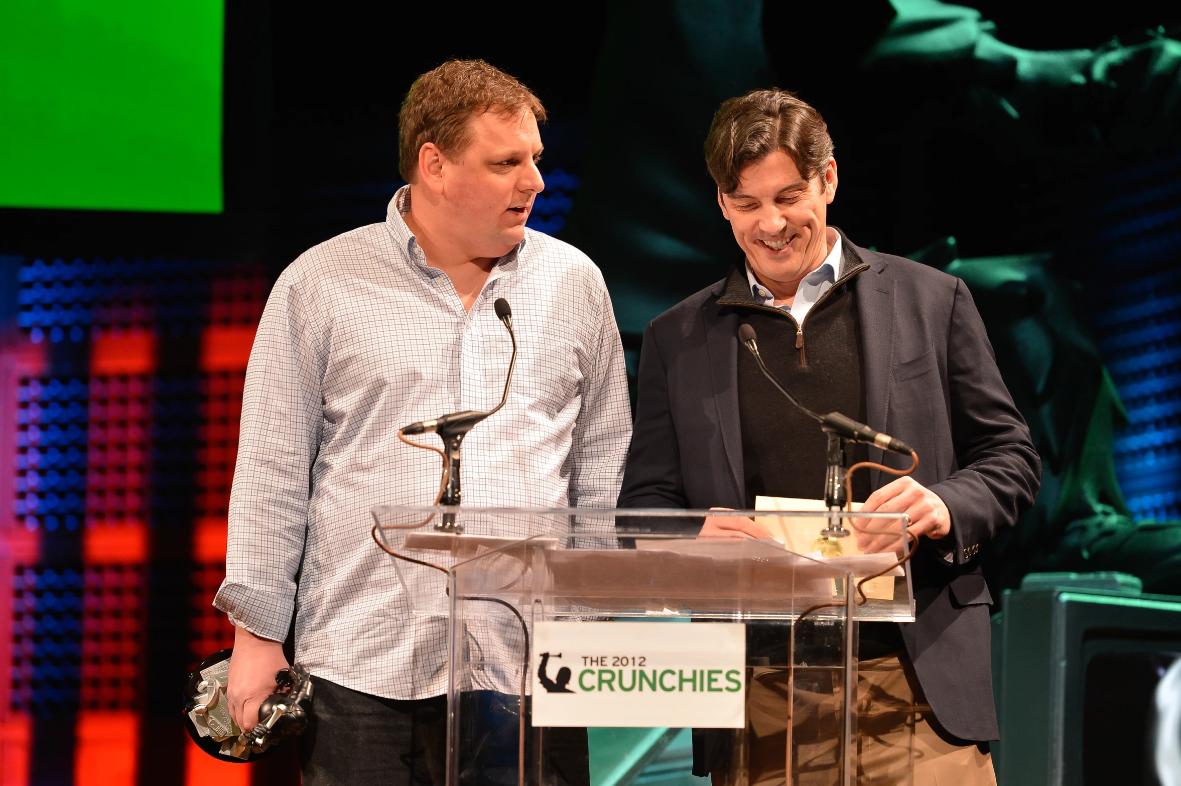 two men who are standing next to each other near a podium