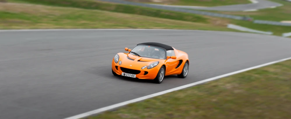 an orange sports car on a curvy road