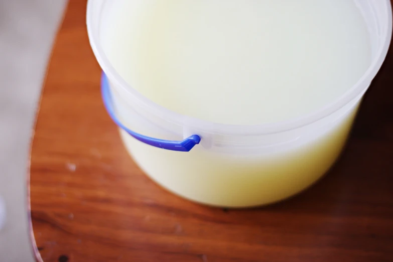 a cup of milk is sitting on a wooden table