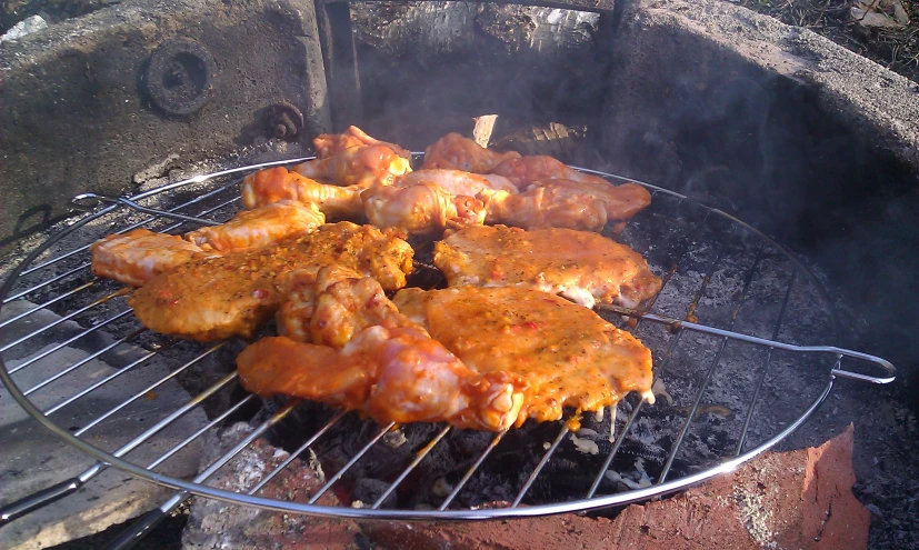 four pieces of meat are cooking on the grill