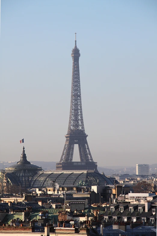 a tall tower stands in the distance with small houses below