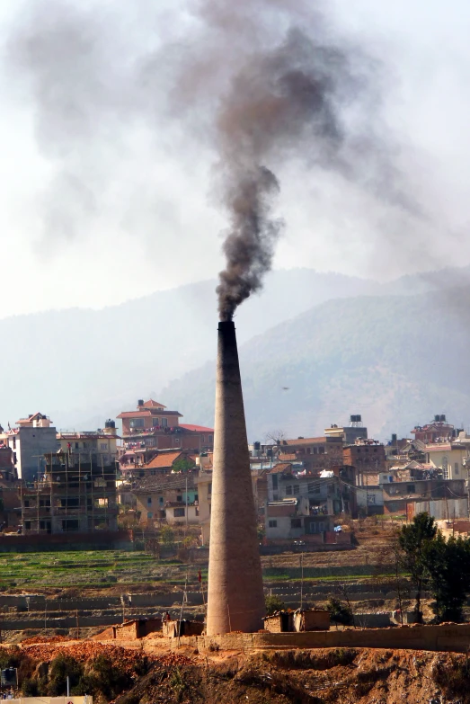 a tall smoke column in the middle of a city