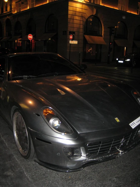 the front end of a sports car parked at night