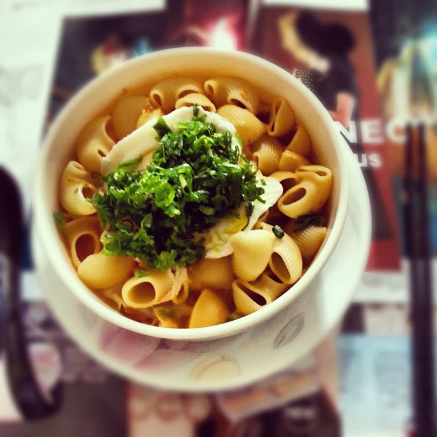 a bowl of pasta with sauce, broccoli and cheese