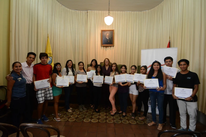 a bunch of young people holding up some paper