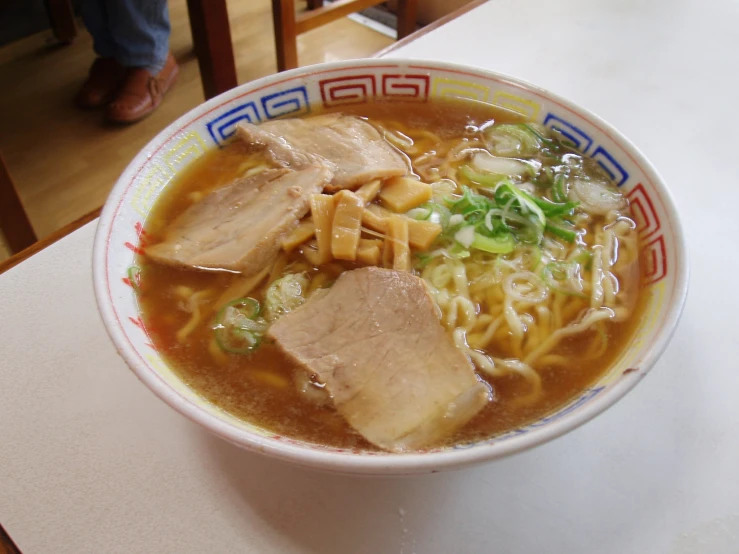 a bowl of soup with meat and vegetables in it