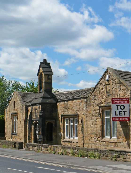 a stone building with a sign in front of it
