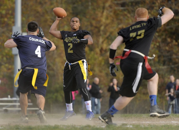 several male athletes are playing frisbee on a field