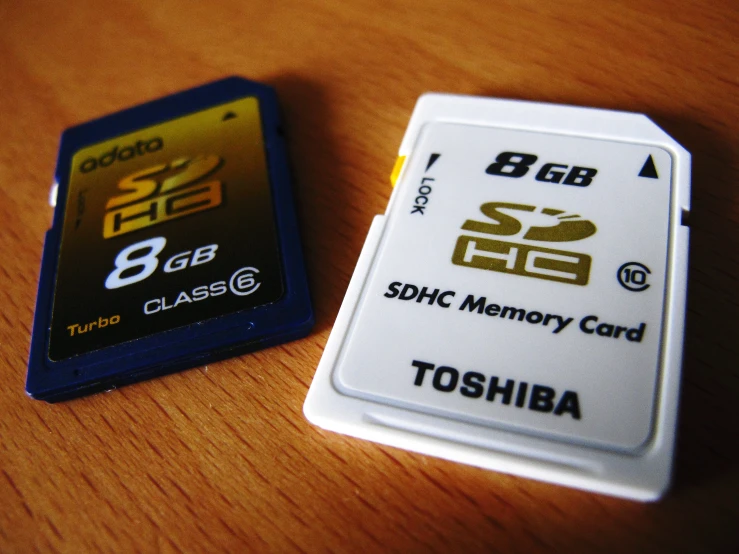 a memory card sitting next to an 8gb sd card