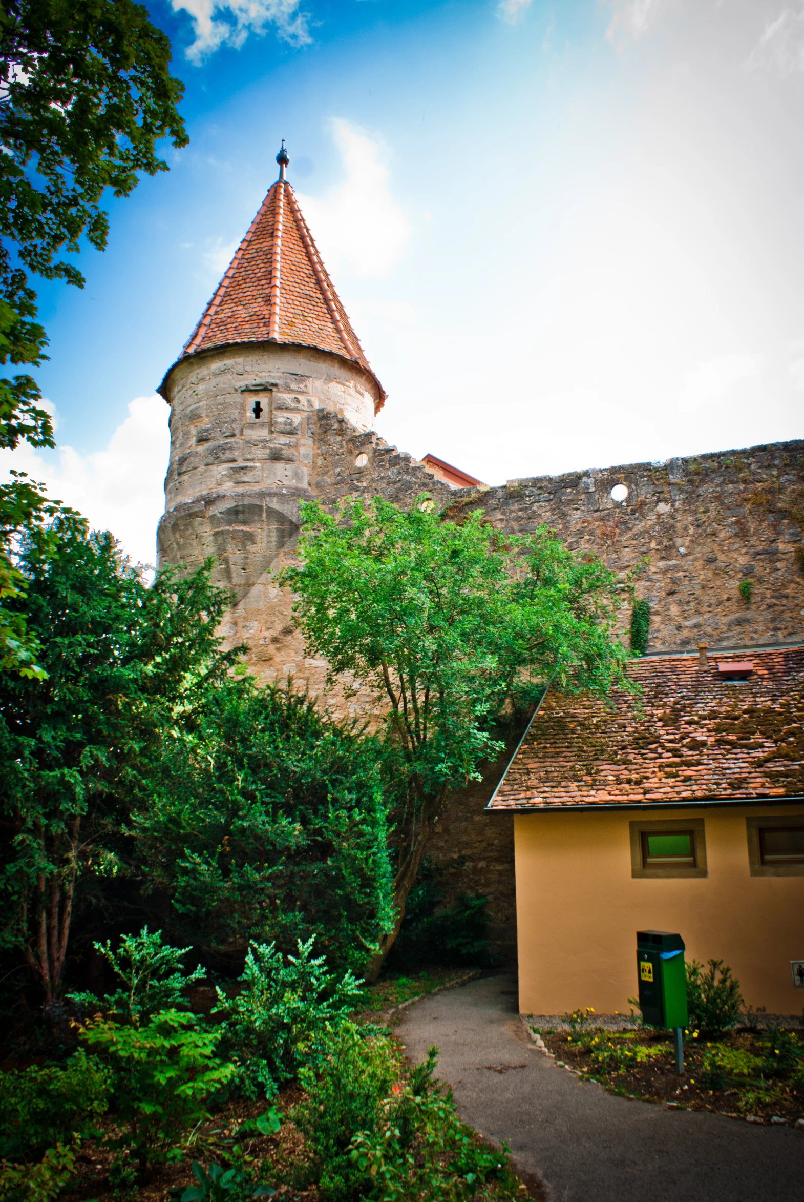 a small building with a tower and a walkway leading to it