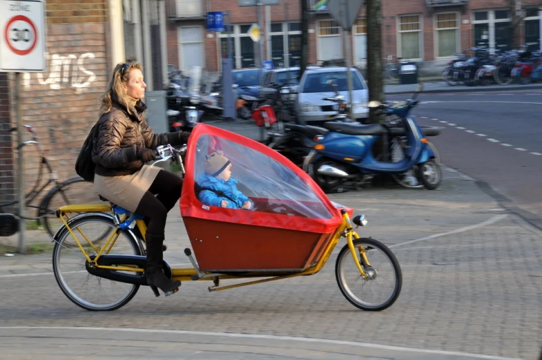 a woman on a bike with a cart attached