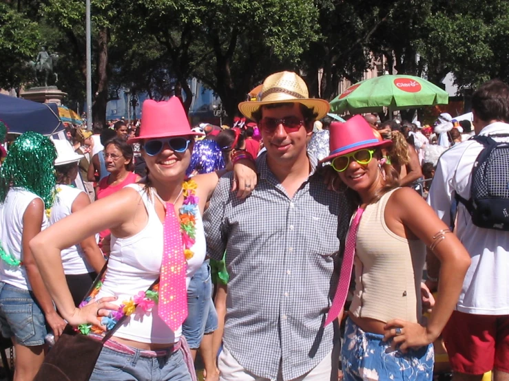 the man and two women are standing together with their hats and ties