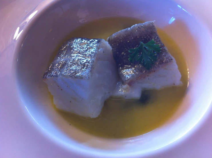 a bowl of soup that contains fish and broth