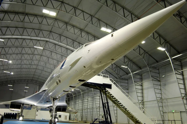 a very long white model plane in a big room