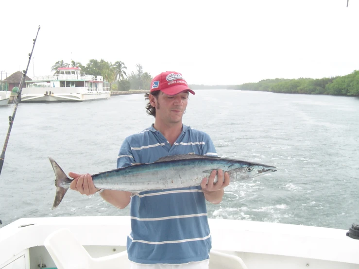 a man holding a large fish on a boat