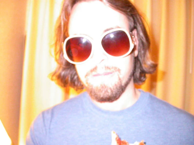 a man with a beard wearing sunglasses looking at the camera