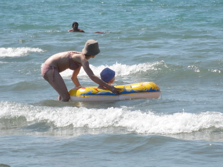 a woman helping a  ride a boogie board