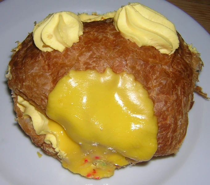 a fried doughnut with er and toppings on a white plate