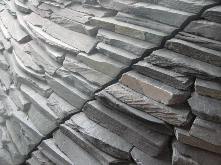 many pieces of slate are stacked to form a wall