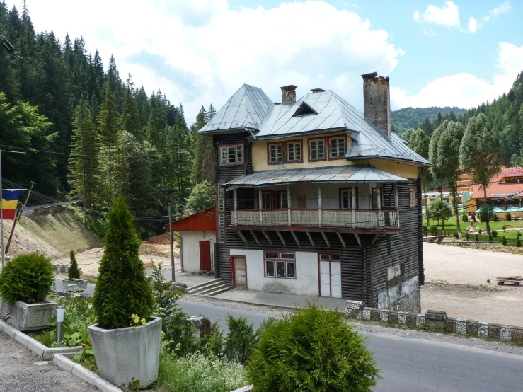 a large house with a gray roof in the middle of trees