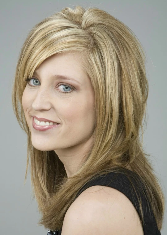 woman with blond hair posing for a studio po