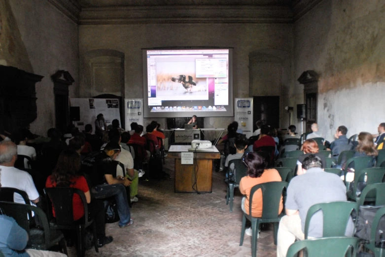 there is a group of people sitting and watching a tv