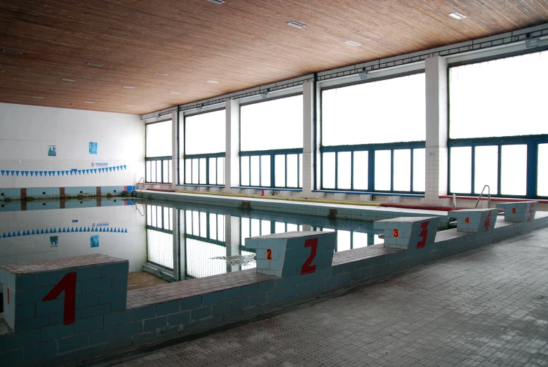 there is a large swimming pool in a very big building