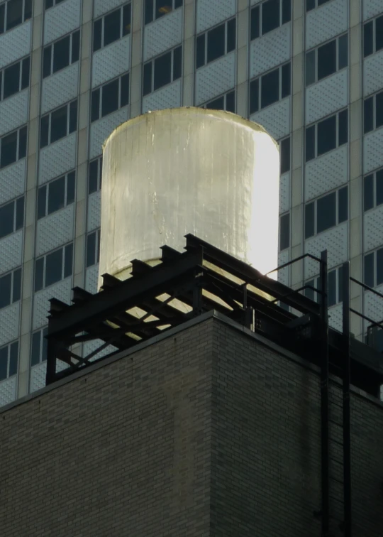 the round water tank is standing on top of the building