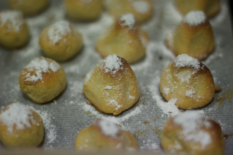 there are some small powdered sugar - covered pastries on a baking sheet