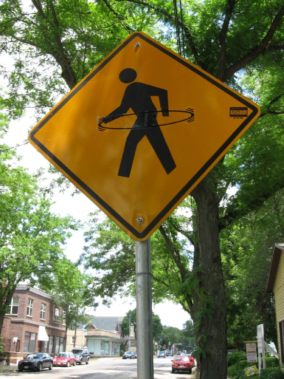 a yellow street sign with a man crossing holding on to strings