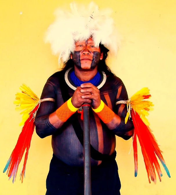 a man standing with several colored feathers on his head