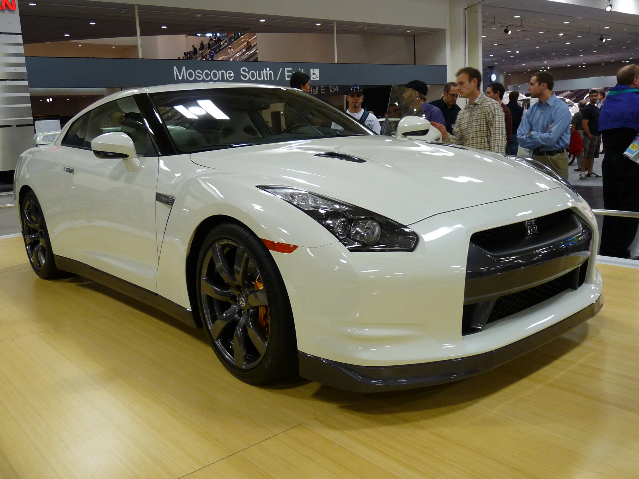 a white sports car with black wheels on display