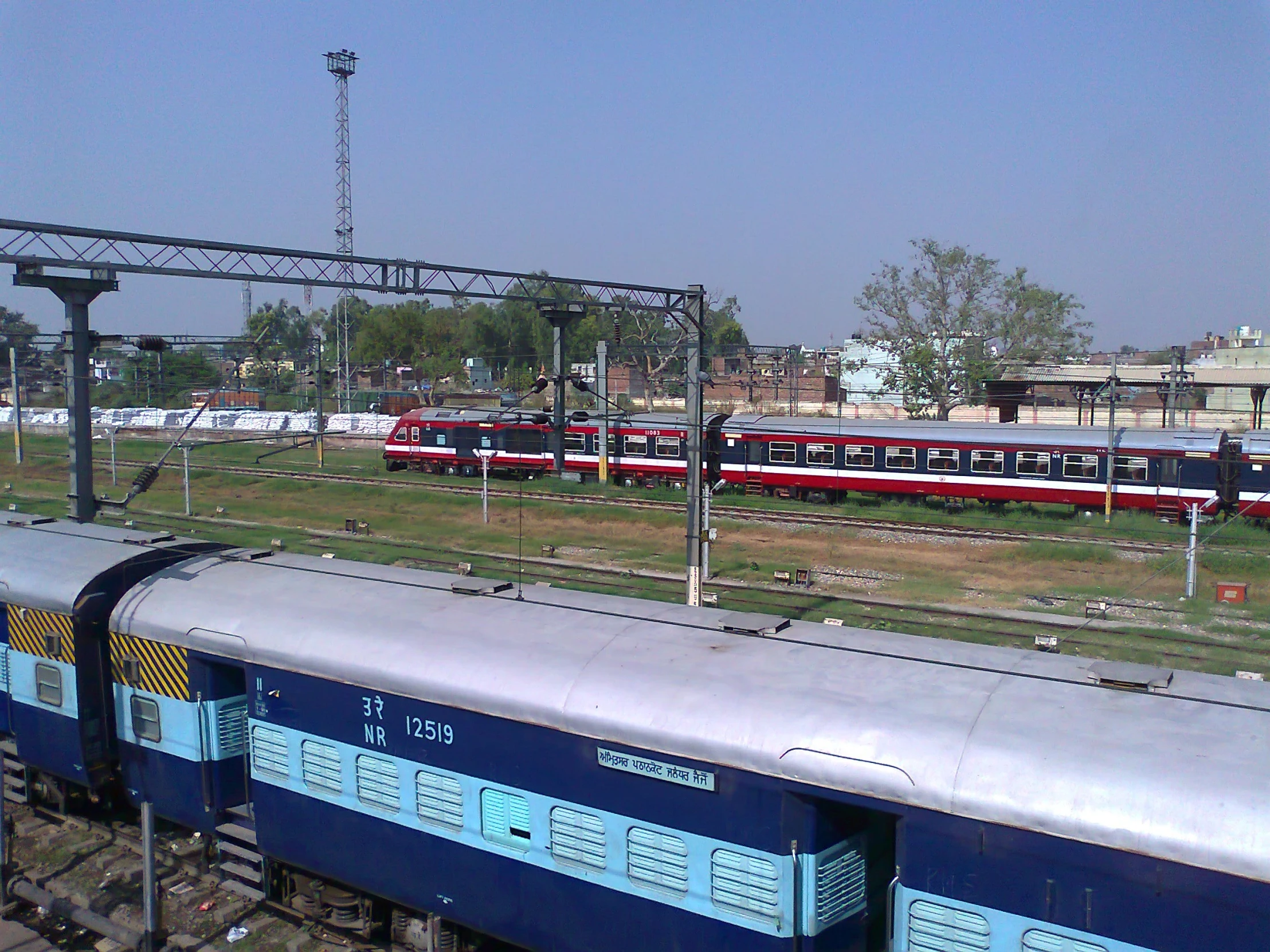 a train traveling down train tracks next to grassy field