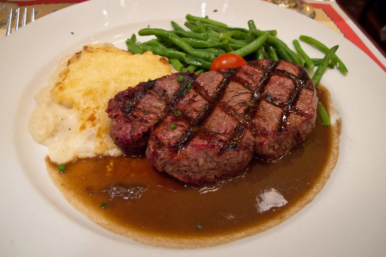 a plate filled with steak, potatoes and gravy