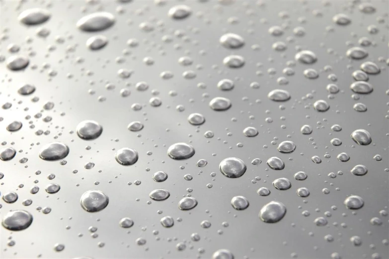 a very many round water drops on a metal surface