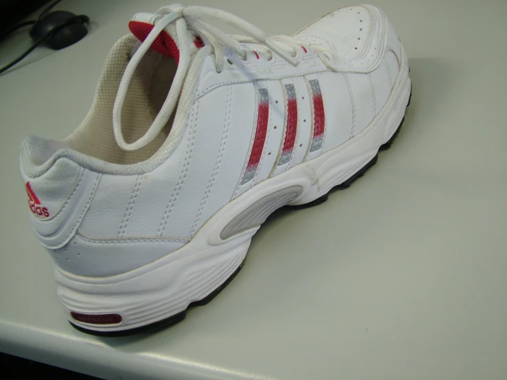 white sneakers with red and grey stripes on a table