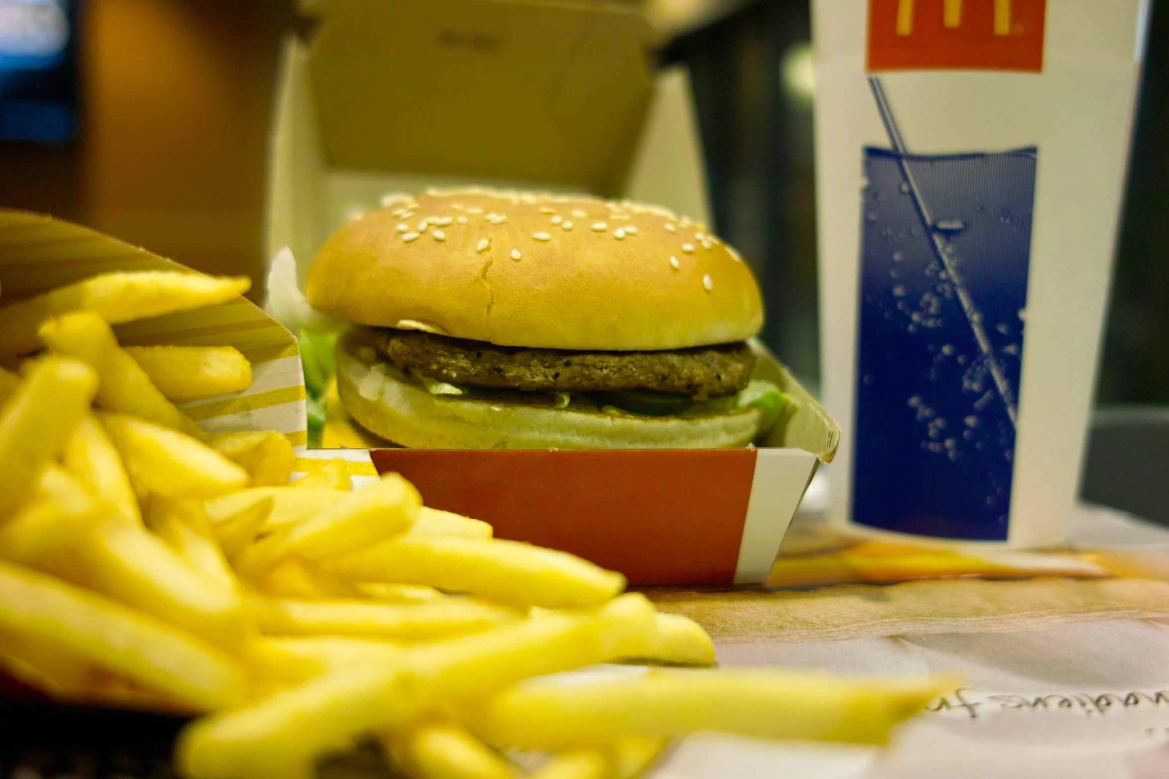 the burger has fries and a drink next to it