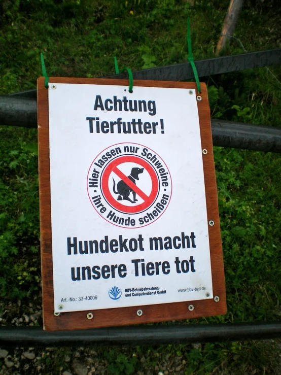 a wooden sign saying no dogs allowed to humans in the wild
