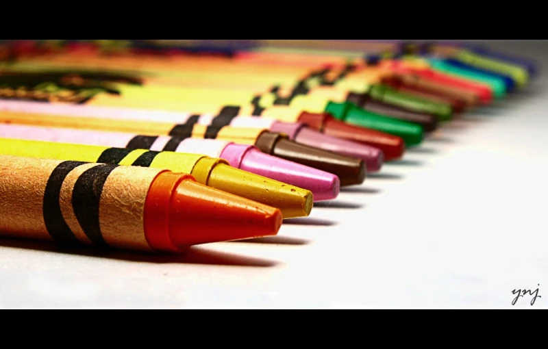 various colored pencils lined up neatly on a surface