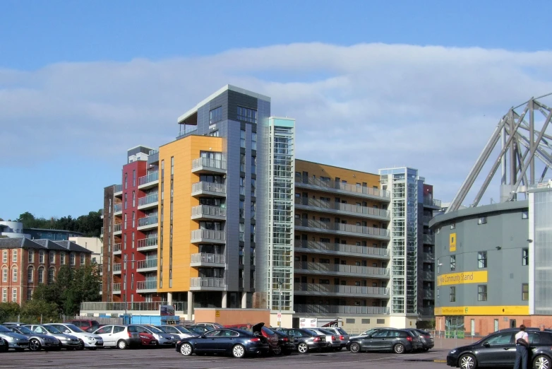 several cars parked outside of some very large buildings