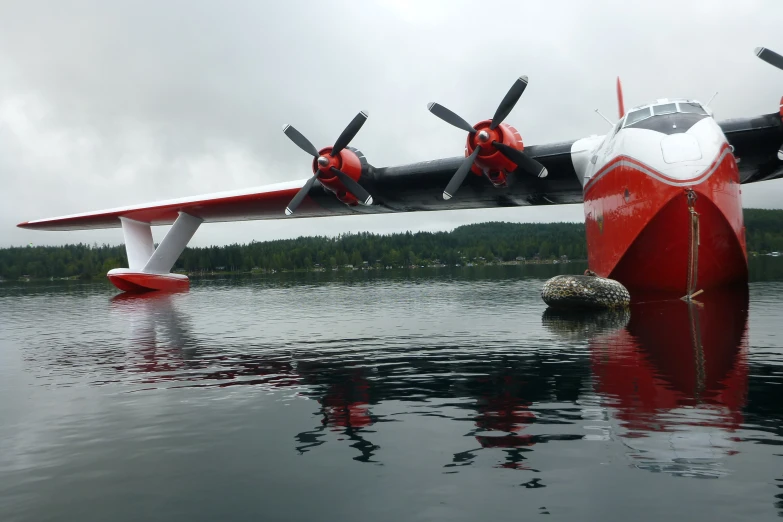two red and white airplanes next to each other near water