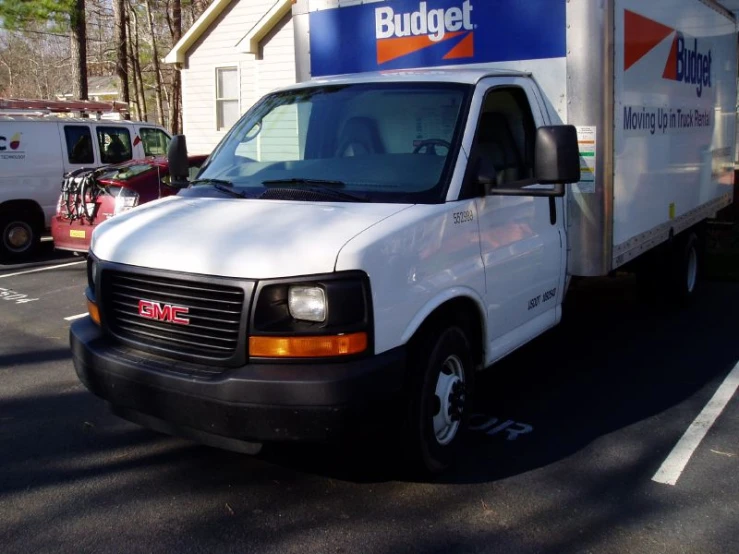 a white budder truck is parked outside a building