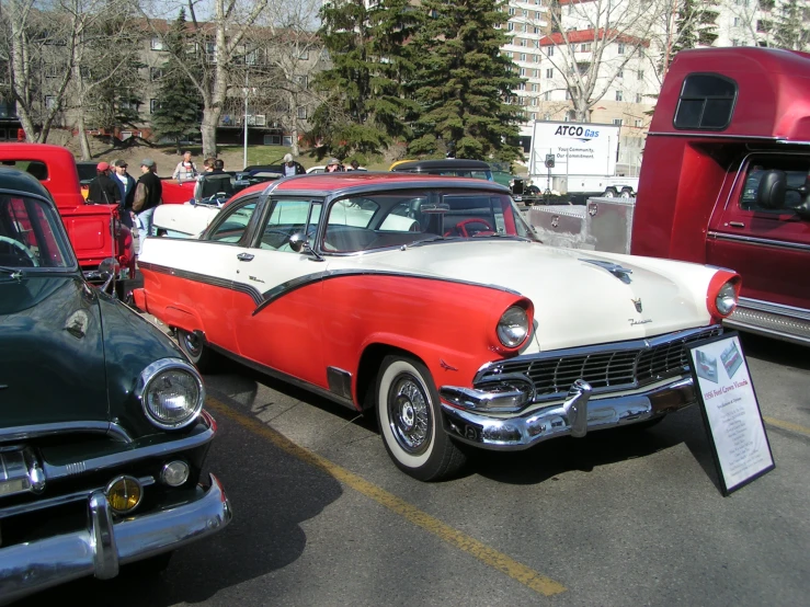 several old cars are parked in a parking lot